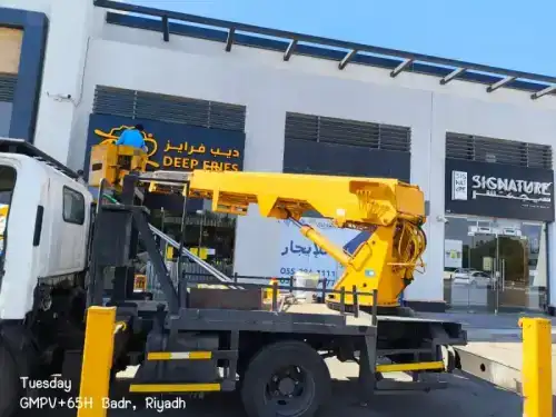 فني شركة الجواد يقوم بتنظيف لوحة إعلانية مضيئة وتلميع الواجهة الزجاجية لمتجر كبير في الرياض