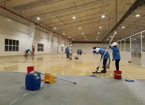 عامل شركة الجواد يستخدم ماكينة السكرب الشاملة (Floor Scrubber) لتنظيف وتلميع صالة سيراميك واسعة في الرياض مع إضافة مواد التعقيم