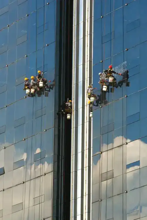 فريق شركة الجواد يستخدم نظام الوصول بالحبال (Rope Access) لتنظيف واجهة زجاجية لبرج إداري شاهق في حي الصحافة بالرياض