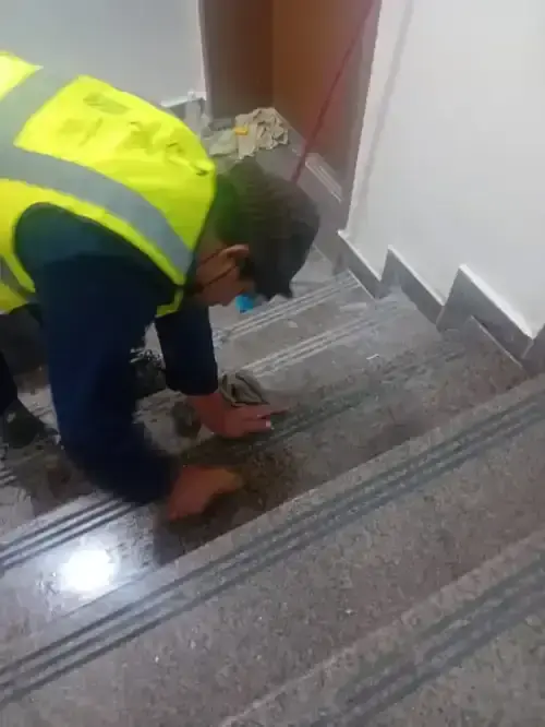 فني شركة الجواد يقوم بعملية جلي وتلميع درج رخام في الرياض باستخدام ماكينات يدوية دقيقة.