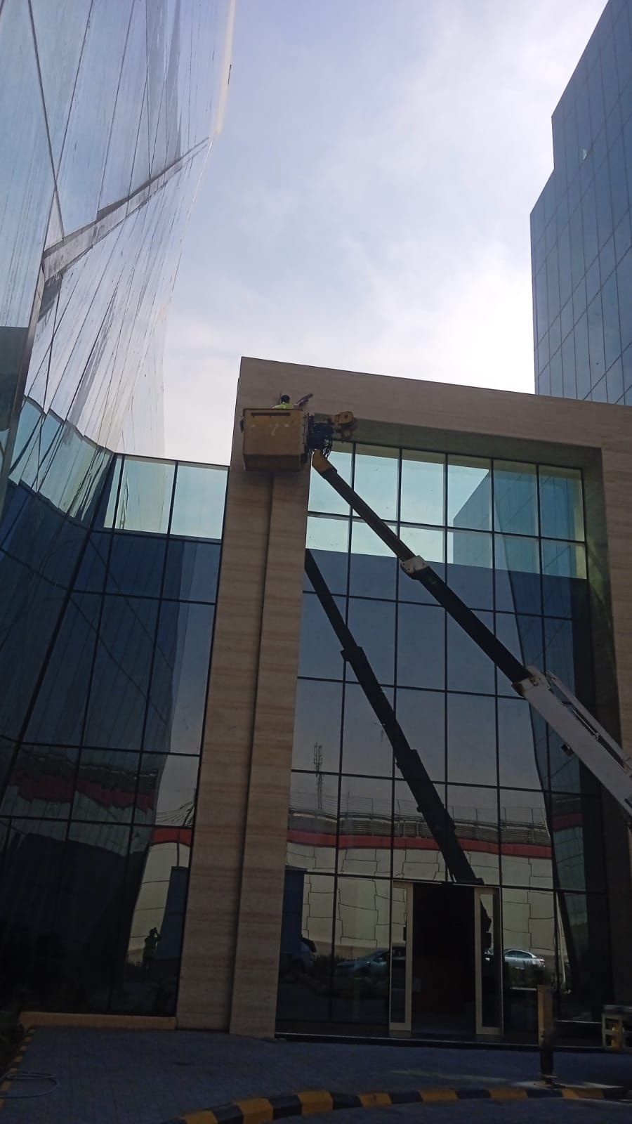 فريق شركة الجواد يقوم بتنظيف واجهة برج فندقي في مكة المكرمة وجلي الرخام في المداخل الرئيسية