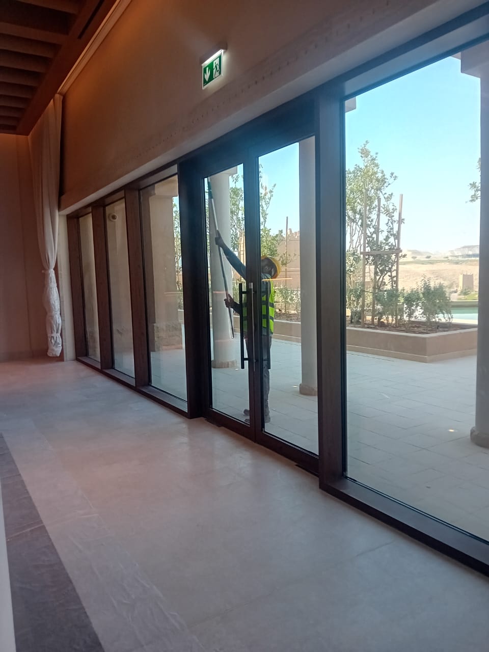 فريق شركة الجواد يقوم بتنظيف واجهة برج إداري بالدمام وحمايته من الرطوبة والصدأ.