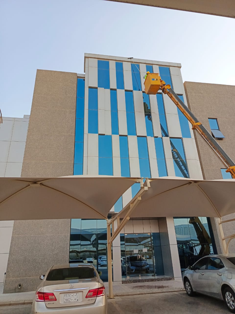 فريق شركة الجواد يقوم بتنظيف واجهة مبنى إداري في حي قرطبة بالرياض باستخدام أحدث معدات التلميع.