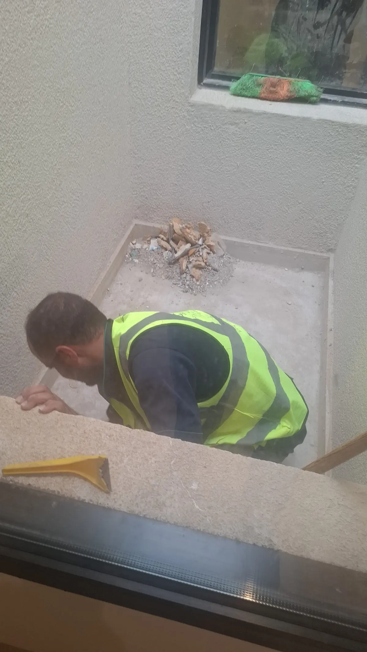 عمال شركة الجواد يقومون برفع مخلفات بناء من منور فيلا تحت الإنشاء في الرياض.