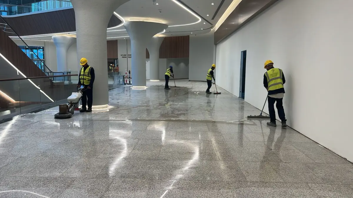ماكينة غسيل أرضيات راكبة (Ride-on Scrubber) تابعة لشركة الجواد تقوم بتنظيف وتلميع أرضية باركنج إيبوكسي خضراء في برج تجاري بالرياض