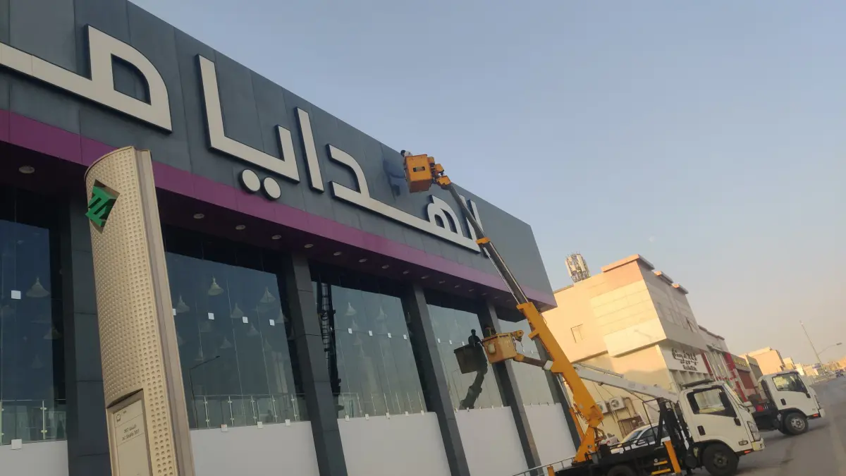عمال شركة الجواد يستخدمون الرافعات لتنظيف واجهات الزجاج والكلادينج لـ الهدايا مول في حي الياسمين بالرياض