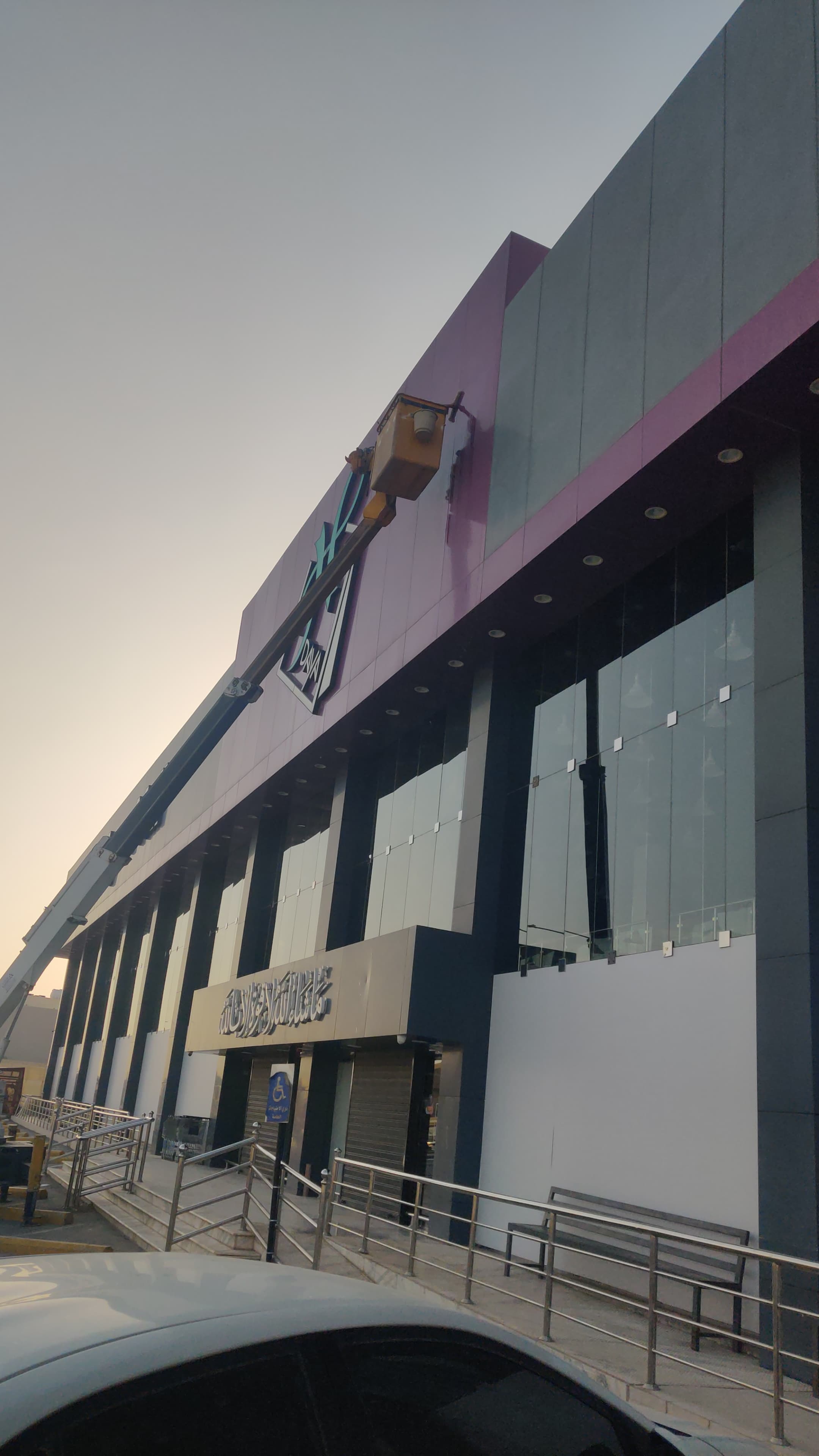 قبل التنظيف - عمال شركة الجواد يستخدمون الرافعات لتنظيف واجهات الزجاج والكلادينج لـ الهدايا مول في حي الياسمين بالرياض