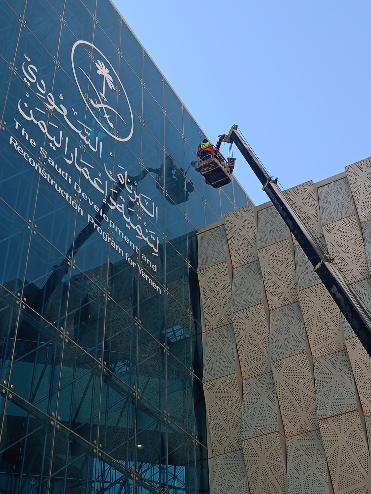 قبل التنظيف - فريق شركة الجواد يقوم بتنظيف وتلميع الواجهة الزجاجية لمقر البرنامج السعودي لتنمية وإعمار اليمن بالرياض