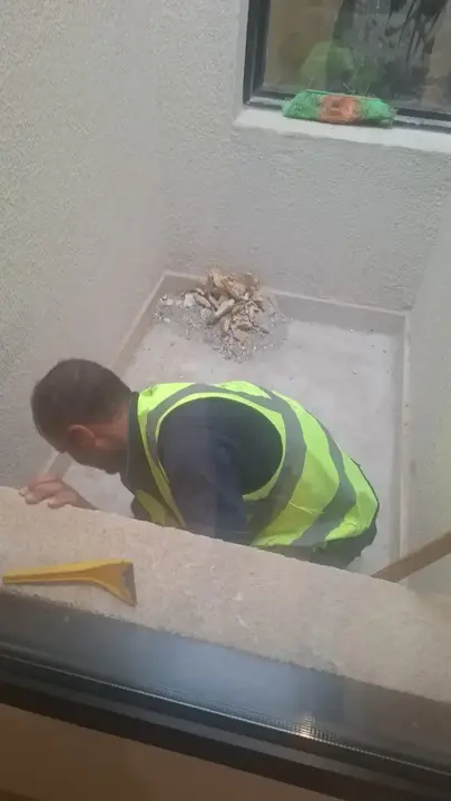 عمال شركة الجواد يقومون برفع مخلفات بناء من منور فيلا تحت الإنشاء في الرياض.