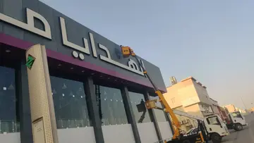 عمال شركة الجواد يستخدمون الرافعات لتنظيف واجهات الزجاج والكلادينج لـ الهدايا مول في حي الياسمين بالرياض